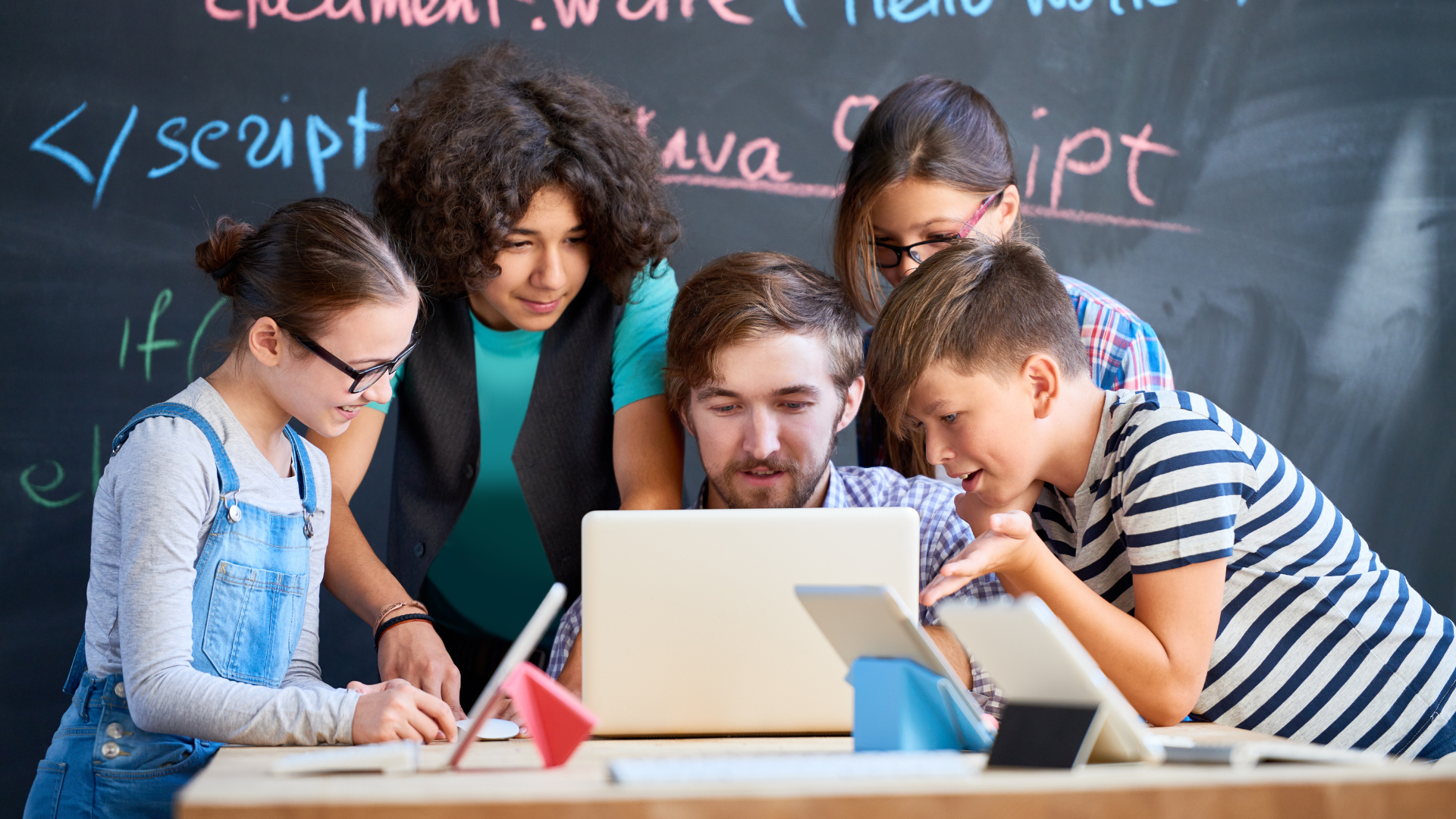 Computing students collaborating around a laptop